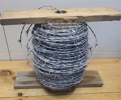 Heavy-Duty Galvanized Barbed Wire Spool on Wooden Carrying Frame